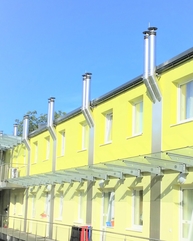 viele Kamine an gelber Hausfassade